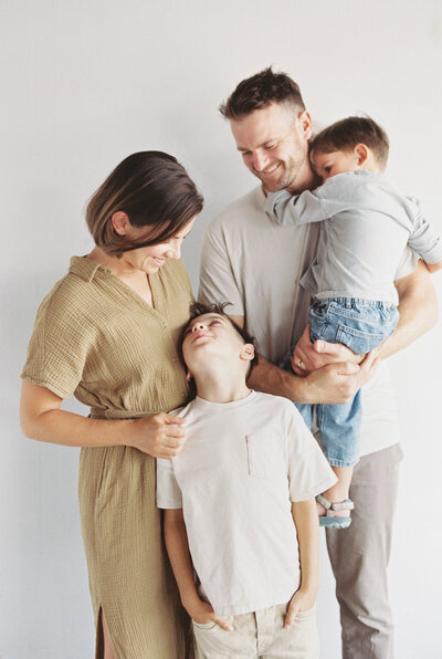 A family of four relaxes into a photo session at the studio with Birmingham photographer Kelsey Dawn Photography