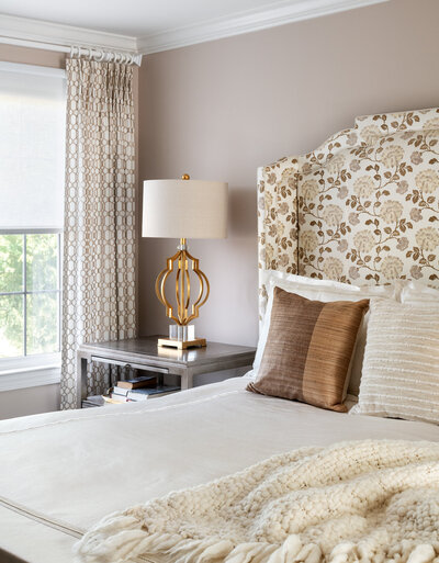 beige wall with beige and white bed in front and curtains