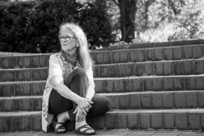 Female author sitting on steps black and white photo