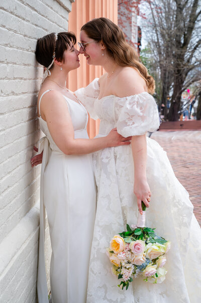 Couple poses together agains wall of building in Leesburg VA