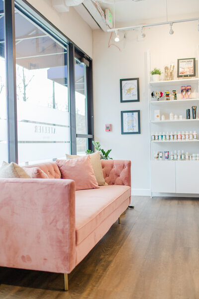 hair salon waiting area pink velvet couch and big window