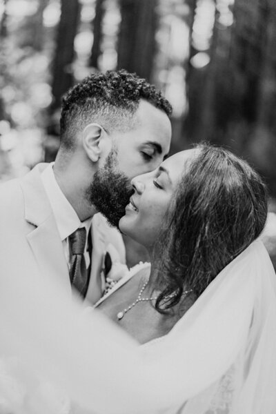 black and white image bride and groom  kissing