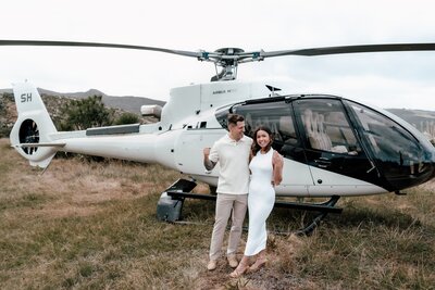 Nikhil and Pranali celebrating proposal beside helicopter in Auckland, photographed by Zanthe Vorsatz.