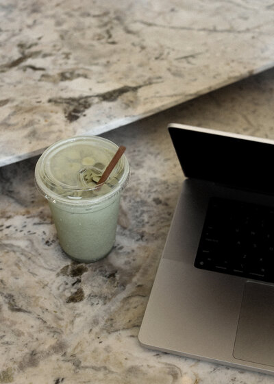 coffee and laptop sitting on a granite countertop