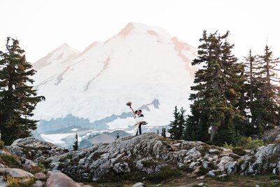 Couple celebrating in front of Mount Baker in their wedding attire