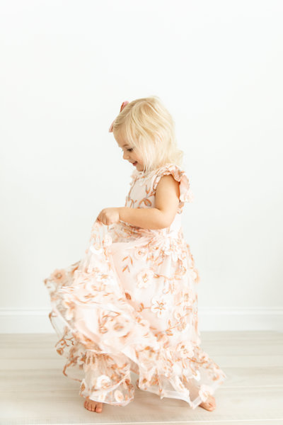 photo of little girl twirling in pink floral dress