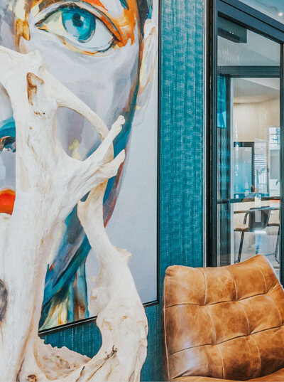 Vibrant lounge at The Apex at Sky Valley with abstract portraits, leather chairs, and modern decor.