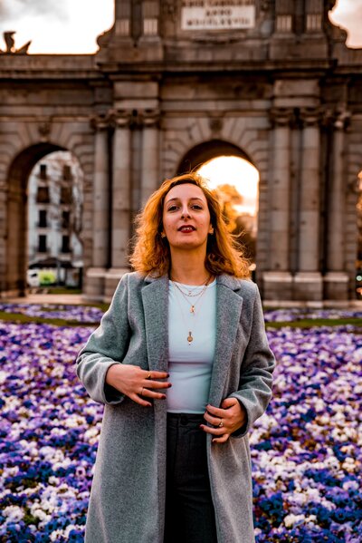 Lady standing in front of Puerta De Alcalá, Madrid, Spain