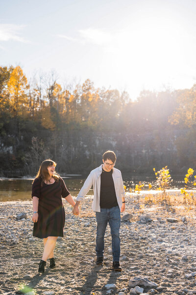 Couple walks together holding hands at the bottom of a quarry.