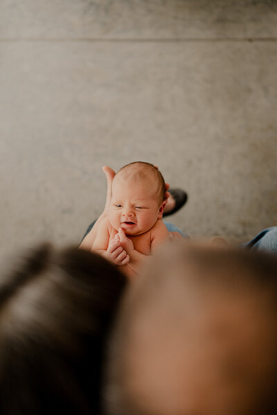 Baby looks at parents in photo taken by Loveland Newborn Photographer