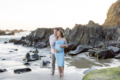 maternity photo on the beach with cliffs and rocks