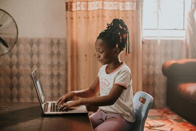 child typing on a laptop