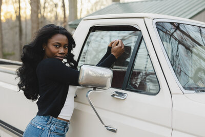A person standing next to a white truck leaning against the window