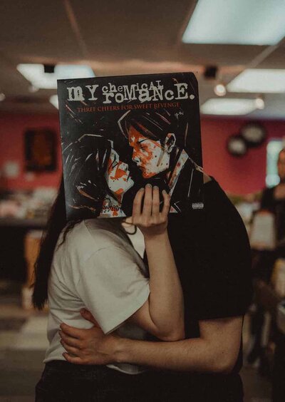 Alternative engagement photos in Minnesota at South Metro Music record store with a My Chemical Romance album