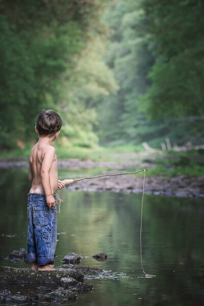 Child fishing in pond for photos at a pond in Princeton, New Jersey.