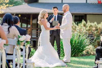 Bride and Groom face each other as the officiant performs the ceremony