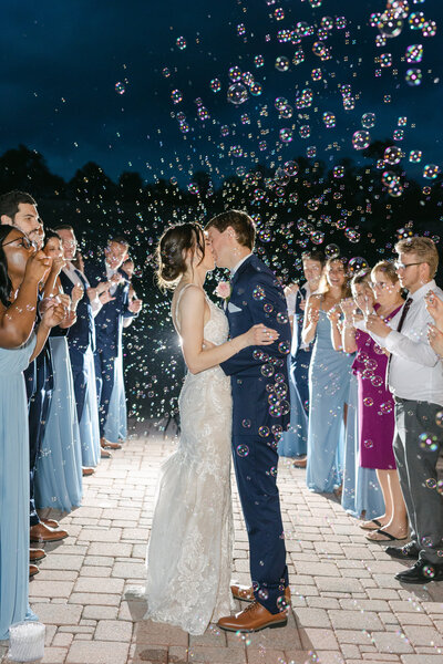 Husband and wife kiss under bubble exit