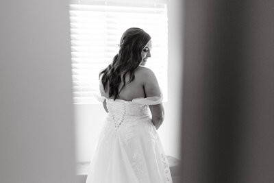 Arizona wedding photographer captures the bride smiling over her shoulder in black and white