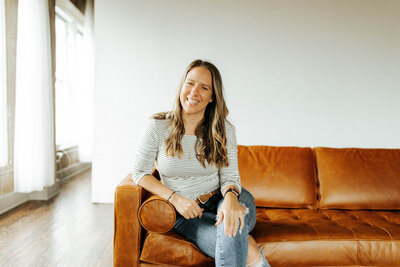 woman sitting on the couch and smiling at the camera