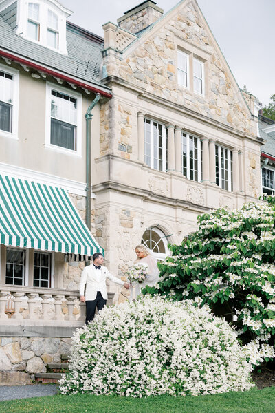 The Corteses Newport Wedding Photographer and Videographer | Serving CT, RI, and beyond | Bride holding a champagne glass with a purple flower