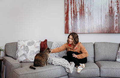 Jen Heller with her cat on a sofa