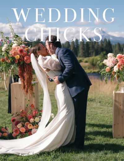 Bride and groom sharing a passionate kiss during their summer wedding ceremony with mountain views in the background.