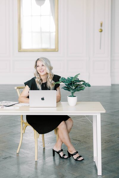 blonde wedding planner works on laptop