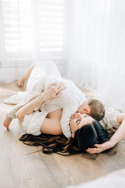 father holding newborn baby while mother hugs them