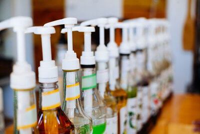 syrup flavors in large pump bottles lined up on a convenience store counter