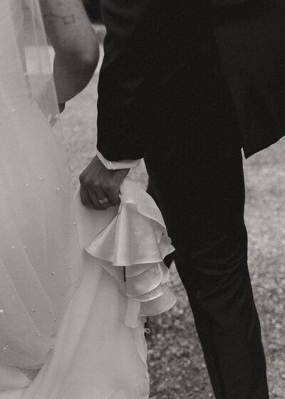 groom holding train of wedding dress