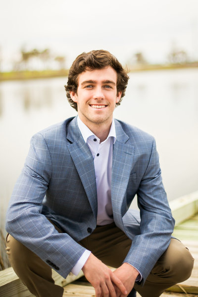 Senior portrait session of teen boy by the waterfront