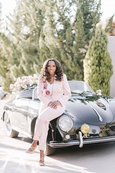 Melissa Williams, a destination wedding planner based in DC, poses next to a classic car.
