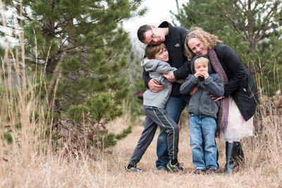 Kelly Loss and her partner hold their two sons in a field
