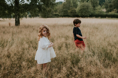 Sibling playing in field for family photos