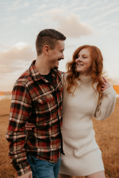 A photo of a couple strolling through the field during their engagment photoshoot in Bloomington, Indiana.