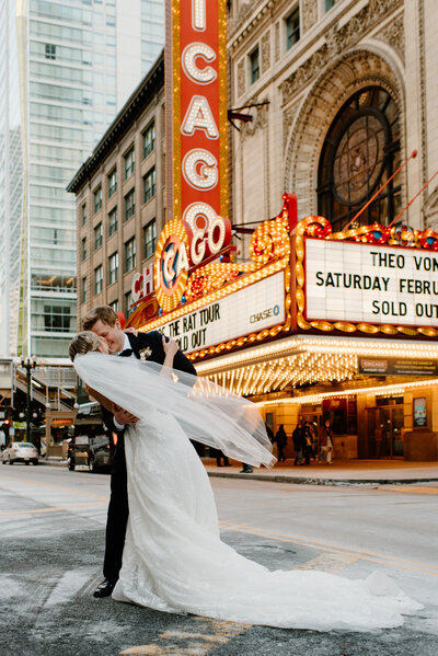 bride and groom kiss in front of the chicago theater
