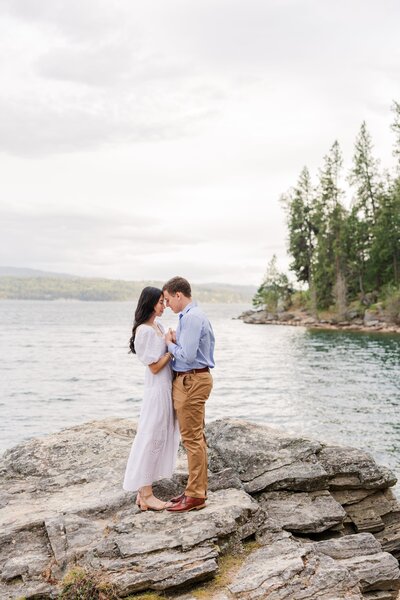 Couple shares a romantic embrace beside Lake Coeur d’Alene in Idaho during their wedding portrait session