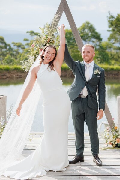 Couple in wedding attire on the beach.