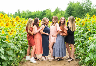 Group of high school senior girls standing in sunflower field