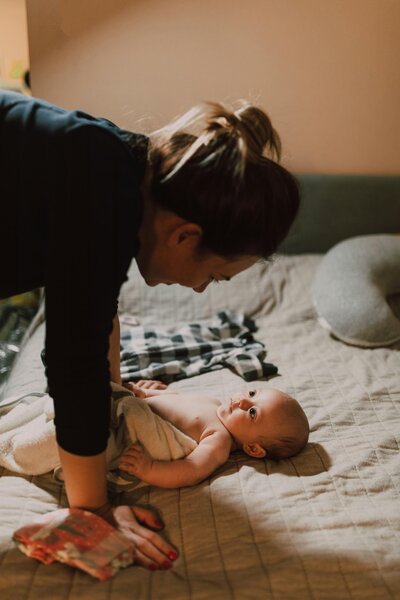 Mother leaning over smiling baby, reflecting emotional connection and healing from perinatal trauma through EMDR