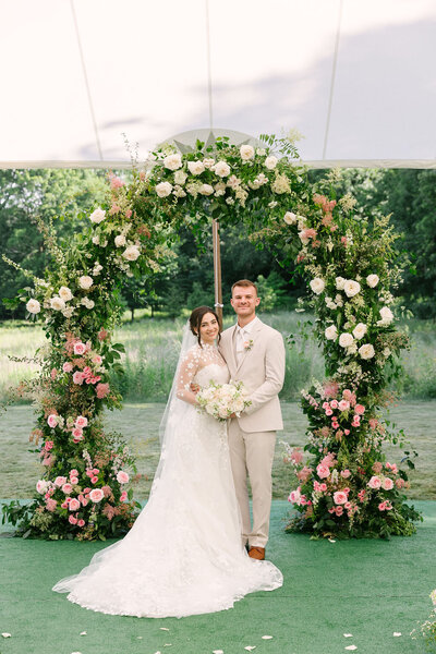 luscious and oversized floral arch for luxury tented wedding, summer prairie hand-picked wildflowers