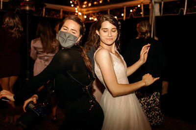 bride dancing with photographer during covid reception