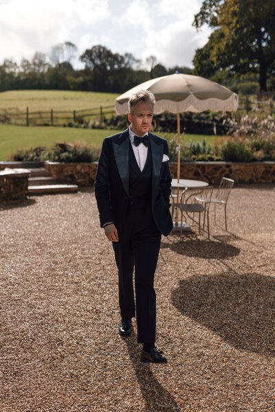 Wedding photographer captures couple taking a stroll hand in hand at their french chateau wedding.