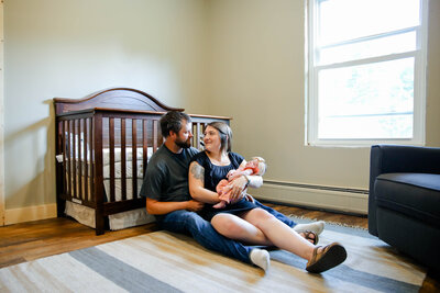 Colored Photo of Parents staring at each other while Mom holds baby | Newborn Photography