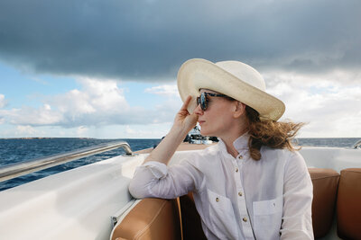 woman holding hat overlooking the Caribbean ocean during photography session
