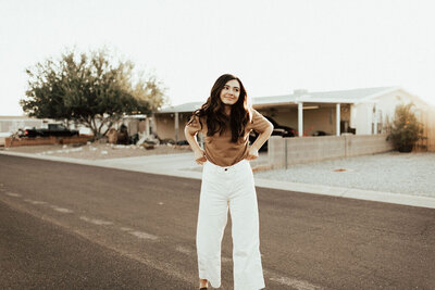 Madi Jeno stands in road smiling away from camera