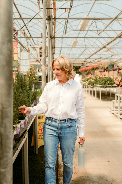 Woman exploring a greenhouse in Minneapolis during a natural light dating profile photography session with Shannon Kathleen Photography. Calm, thoughtful, and relaxed vibe.