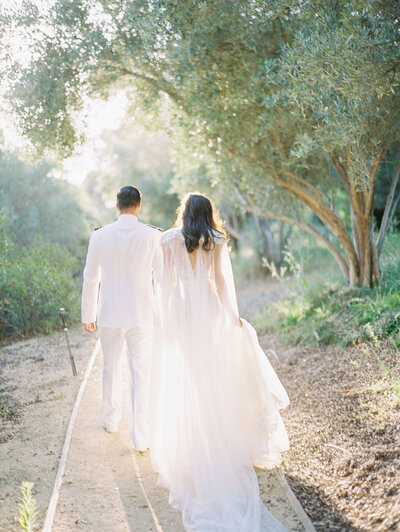 bride and groom walking across bridge at west coast wedding