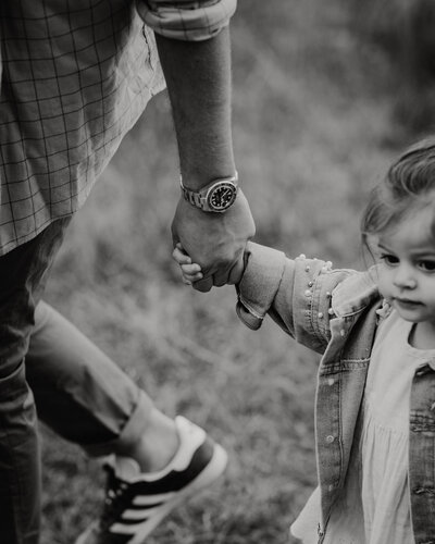 Close up of toddler holding her daddy's hand