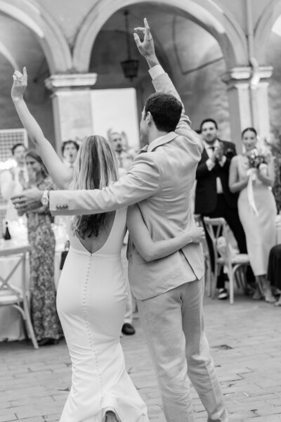 A celebratory photo of a Bride and Groom entering their reception with hands raised by Florida Wedding Photographer Angelika Krug Photo & Film. 